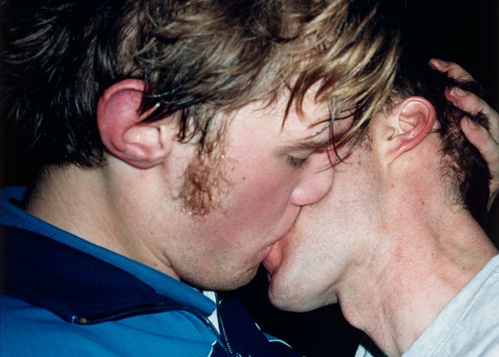 Two men kissing, as seen on the front cover of Young Mungo by Douglas Stuart