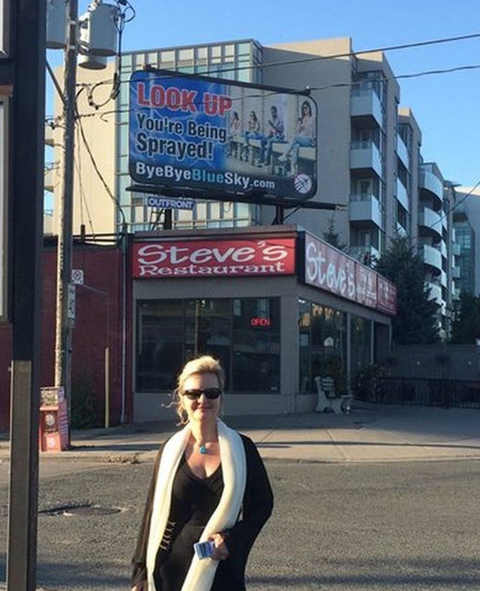 Suzanne Maher foran en Bye Bye Blue Sky-reklametavle i Toronto