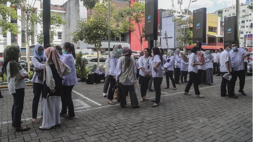 People stay outside amid fears of aftershocks following an earthquake at a business area in Jakarta, Indonesia, 21 November 2022.