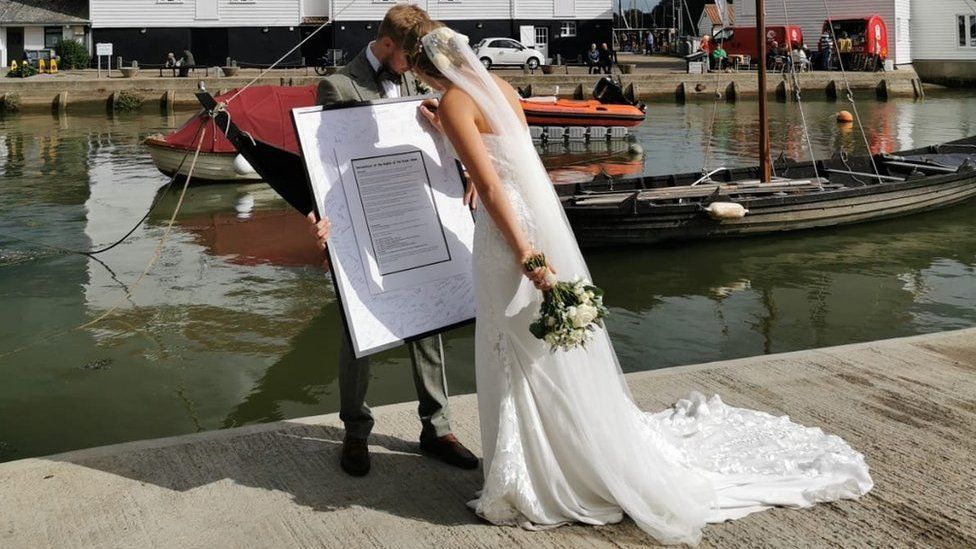 A newly married couple signing the declaration at Whisstocks Quay in Woodbridge