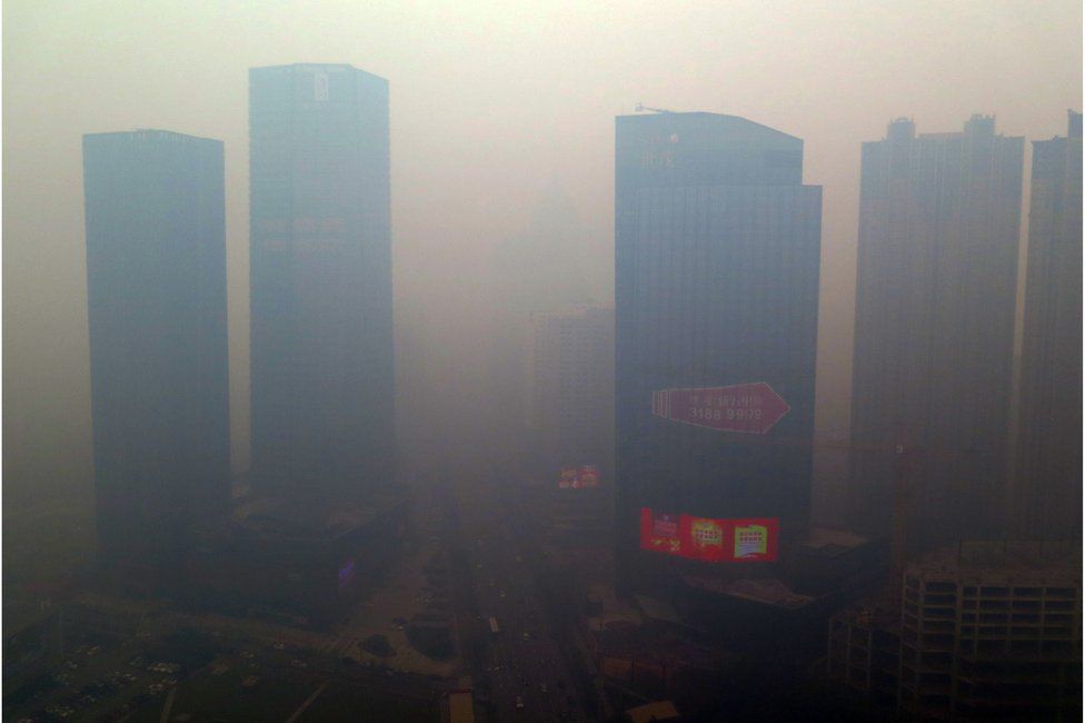 This picture taken on 8 November 2015 shows a residential block covered in smog in Shenyang, China's Liaoning province