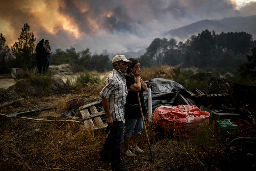 Locals look on as a wildfire advancing in Orjais, Covilha council in central Portugal, on August 16, 2022.