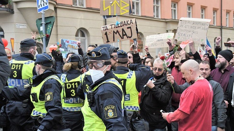 Police officers take a protester into custody in Stockholm, Sweden
