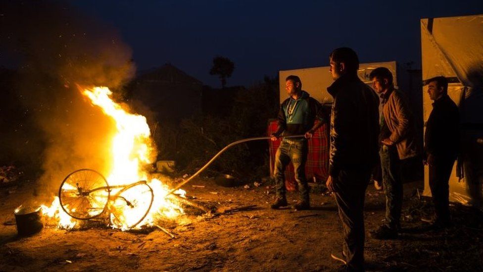 Migrants burn their bikes in a bonfire at the Jungle camp, Calais, northern France. Photo: 24 October 2016
