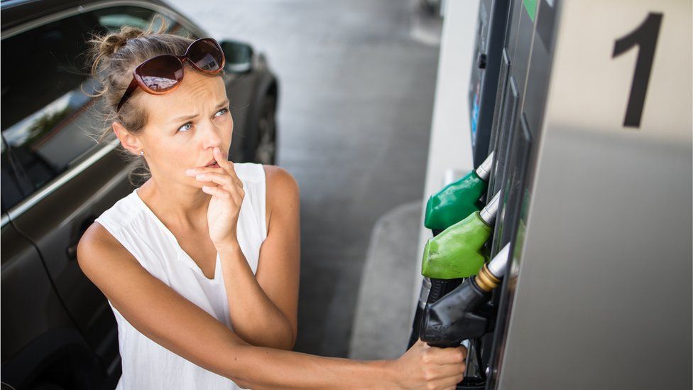 Woman astatine  a petrol pump