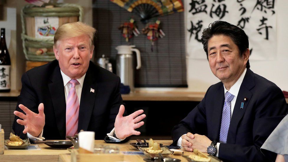 U.S. President Donald Trump talks with Japanese Prime Minister Shinzo Abe during a couples dinner with first lady Melania Trump and Abe"s wife Akie in Tokyo