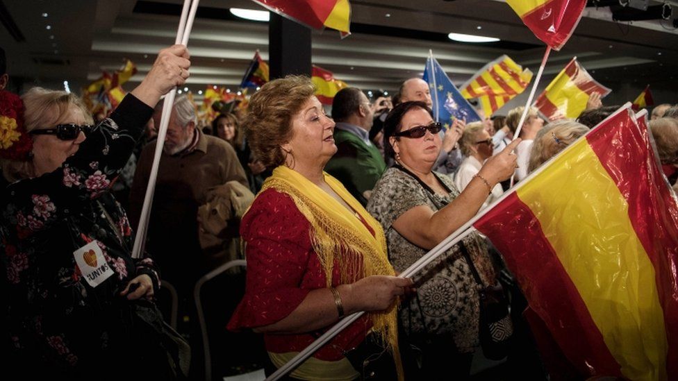 Supports of Spanish Prime Minister Mariano Rajoy wave flags