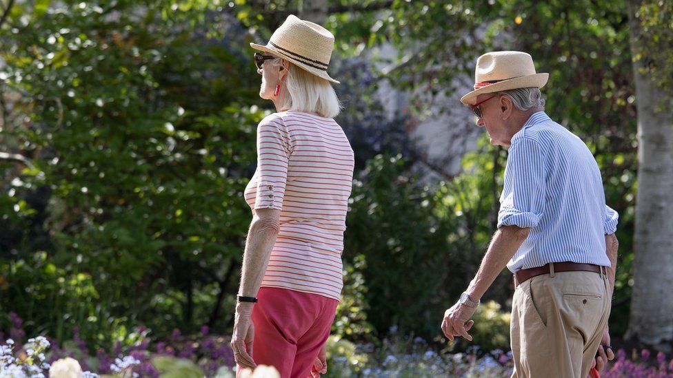 An elderly couple walking through Regent's Park on a warm, sunny afternoon on May 09, 2020 in London, United Kingdom.