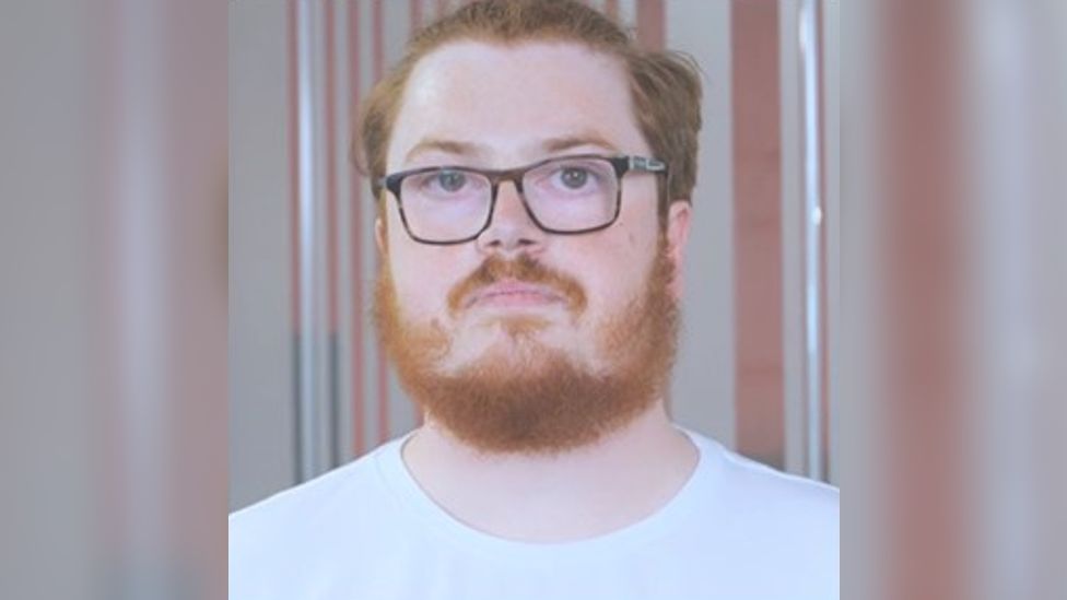 Adam Edwards wearing a white t-shirt and glasses