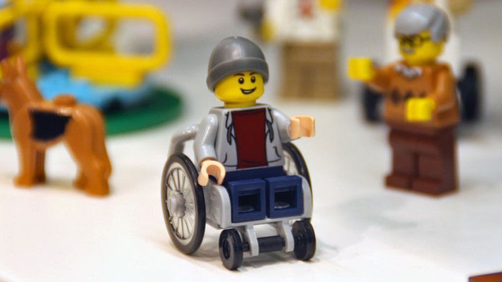 Молодой человек в инвалидной коляске использует фигурку