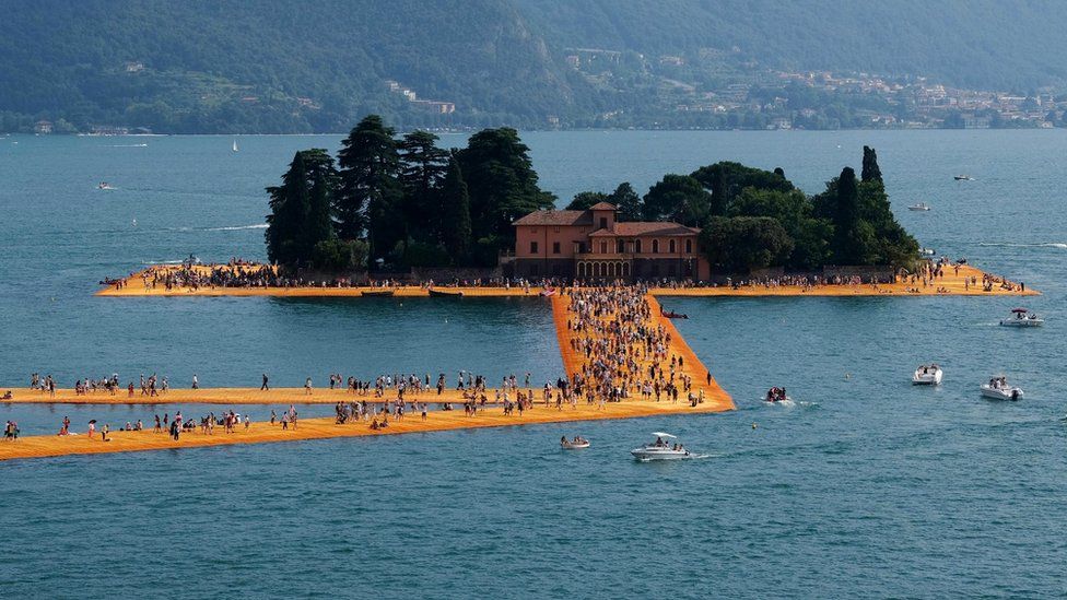 A general view shows people walking "The Floating Piers" by Christo and Jeanne-Claude on Lake Iseo, 3 July 2016