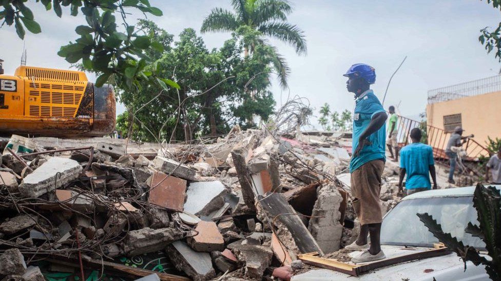 A worker surveys rubble