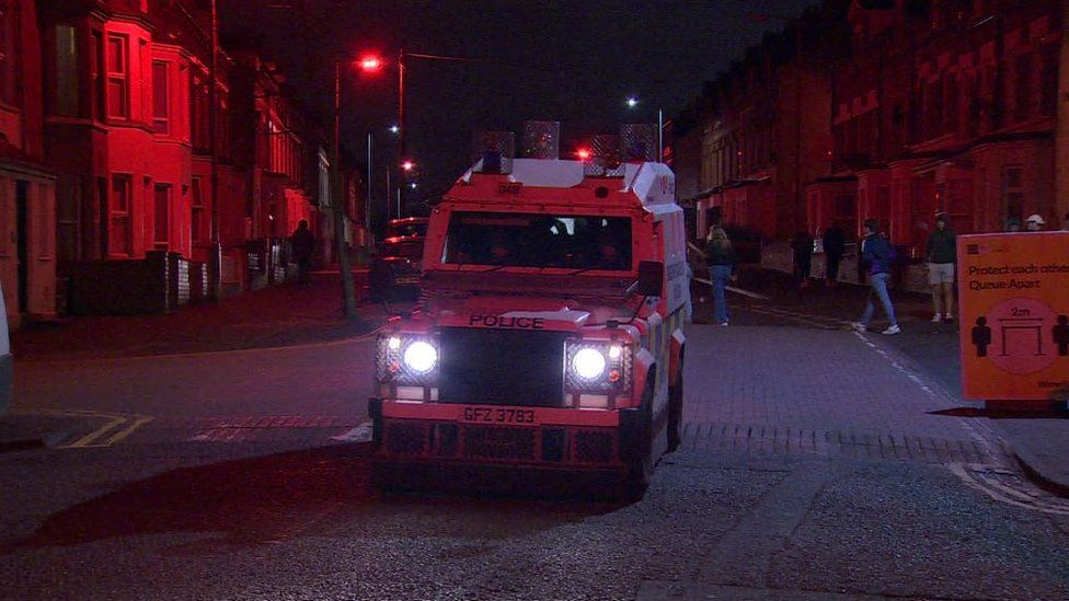 A police vehicle in the Holyland area of Belfast, driving through the streets a night