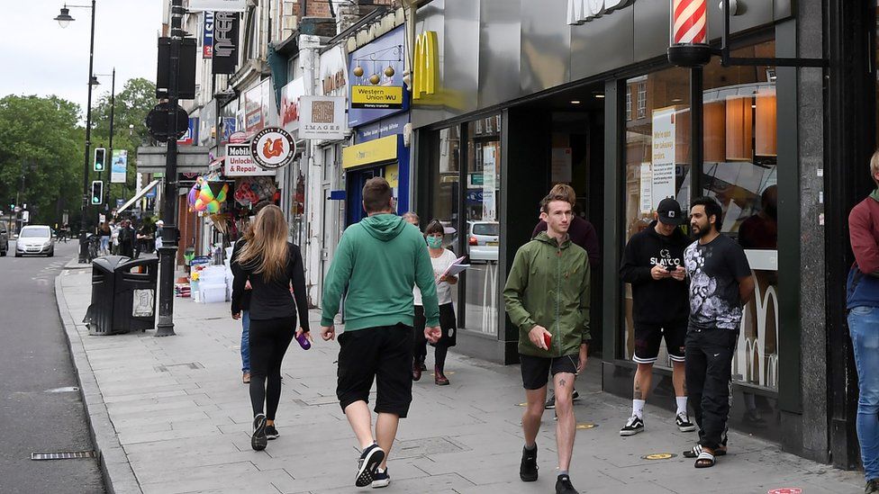 File image of people walking along Clapham High Street in Lambeth, south-west London.