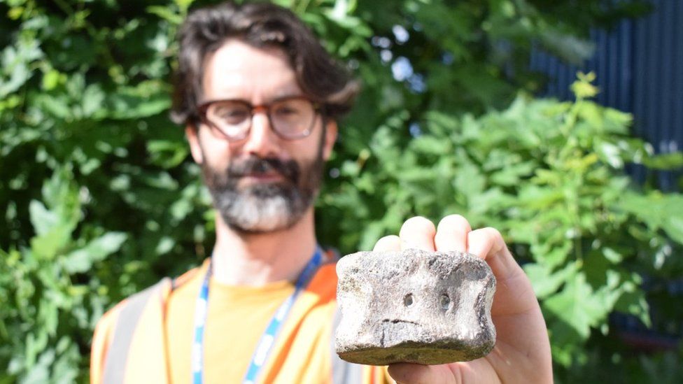 Matt Edwards shown slightly out of focus with plesiosaur bone which is about the same size as the palm of his hand