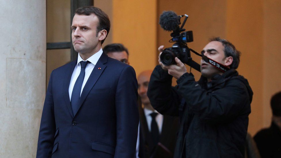 A cameraman films French President Emmanuel Macron at the Elysee Palace in Paris