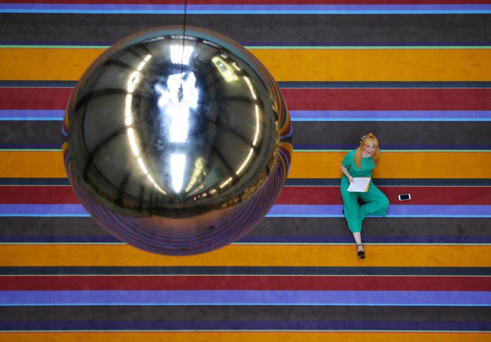 A woman looking up at a giant pendulum, part of a large-scale interactive installation by Danish collective SUPERFLEX, during the unveiling of the Tate Modern Hyundai Commission 2017, at the Tate Modern in central London.