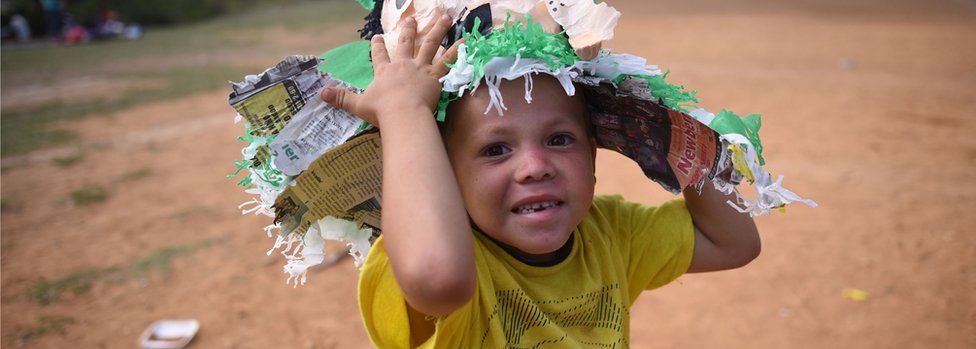 A child who is part of the migrant's caravan playing in a sports field