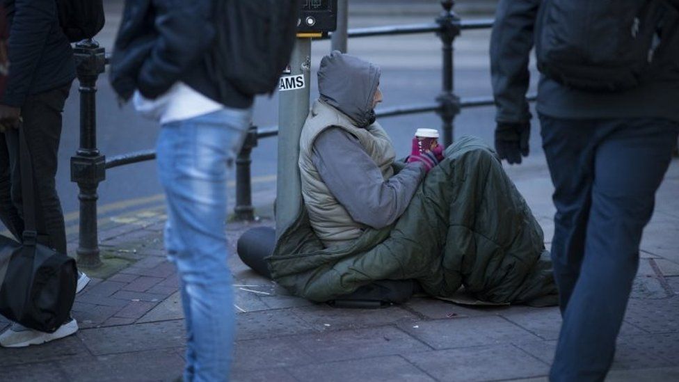 A homeless man begs for small change on the streets of Manchester
