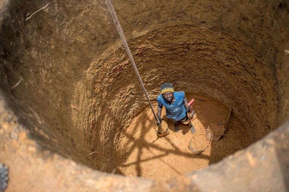 A workman pauses from digging a well for the new settlement in Six Mile
