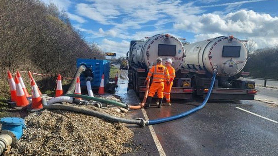 National Highways staff removing water from the A14