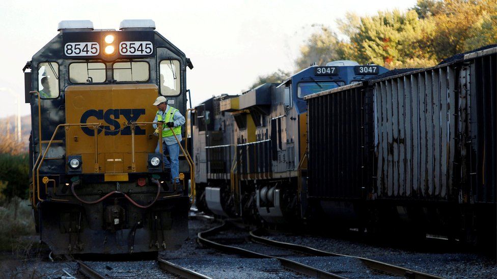 A CSX coal train moves past an idling CSX engine at the switchyard in Brunswick, Maryland (October 16, 2012)