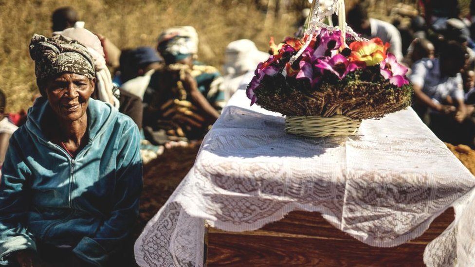 The mother of Ishmael Kumire, 42, sits next to her son's coffin during his funeral ceremony after he was shot during post-election violence on August 1 in Harare, at his homestead in Chinamhora village, Domboshava, outside Harare, on August 4, 2018