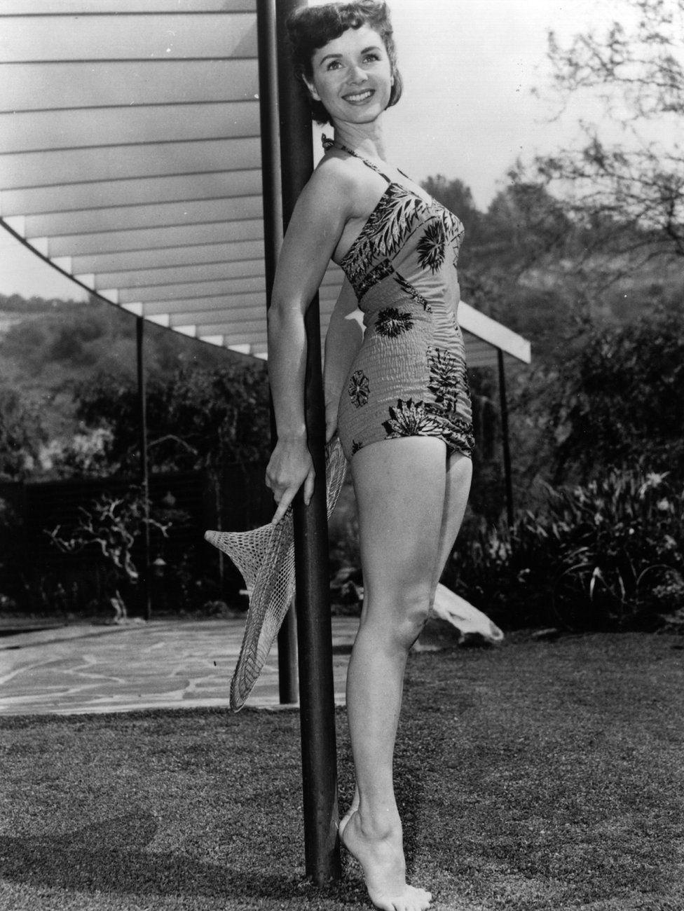 American actress, Debbie Reynolds modelling a swimsuit in the garden. Original Publication: