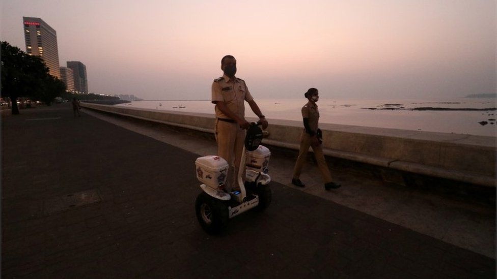 Полицейский патрулирует сегвей вдоль набережной Марин-Драйв во время ограничений, направленных на ограничение общественных собраний на фоне распространения коронавирусной болезни (COVID-19), в Мумбаи, Индия, 3 января 2022 г.