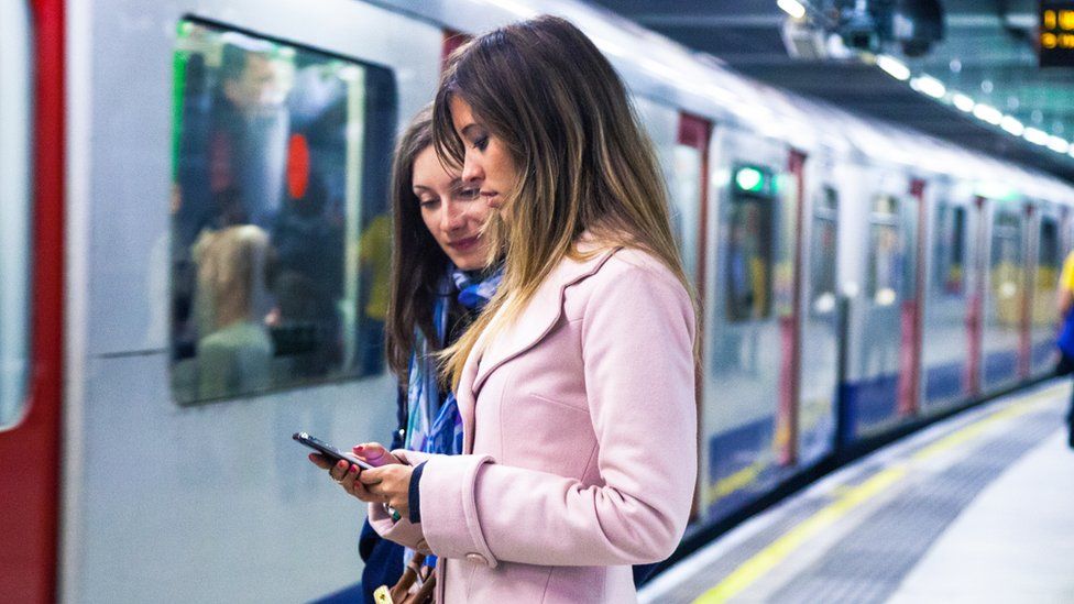 People using mobile on the Tube
