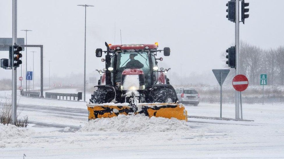 A snowplough clears snow from a road in Aalborg, Denmark