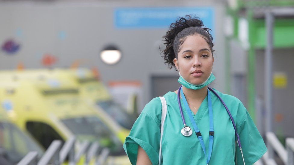 Stock photo of a doctor in scrubs leaving a hospital