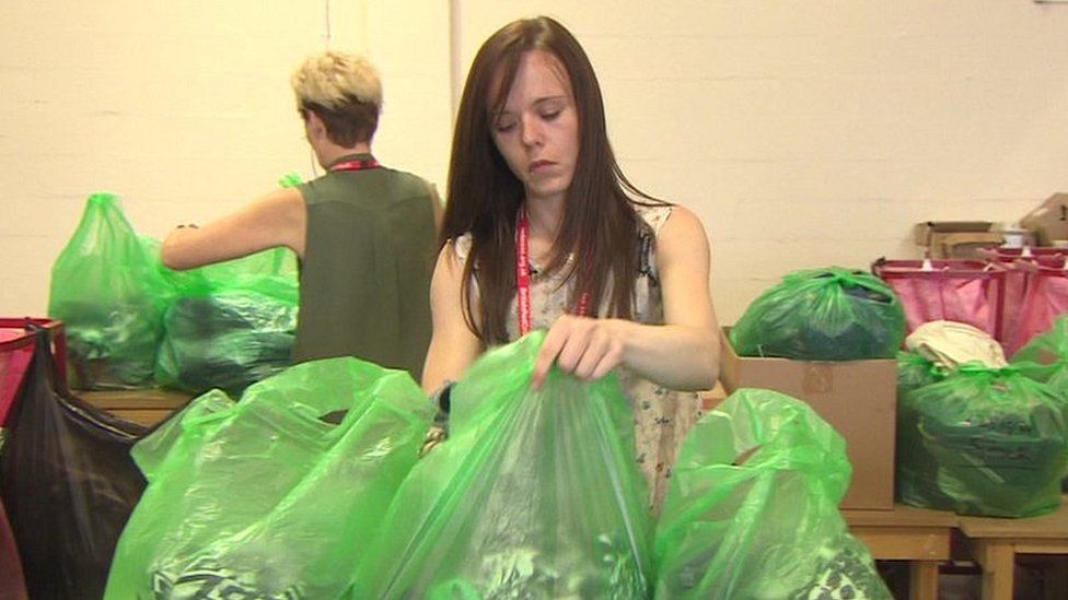 Woman sorts clothes donations