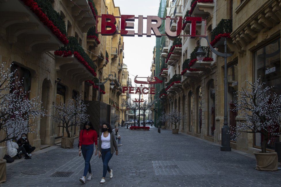Two women wearing masks walk through a street in downtown Beirut, Lebanon (9 January 2021)