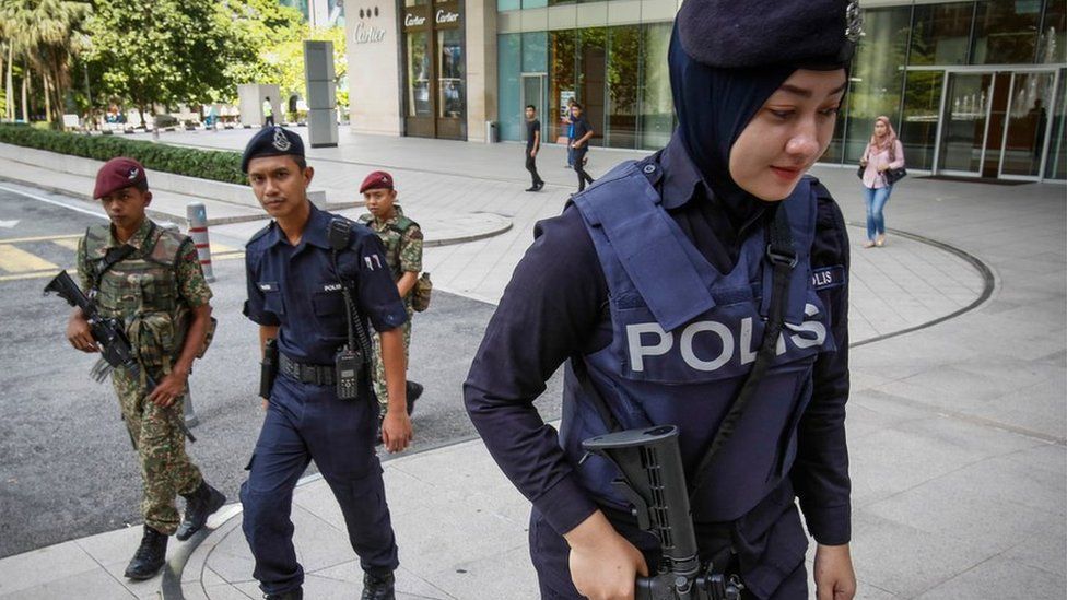 Malaysian military and police personnel patrol an outside shopping mall in Kuala Lumpur
