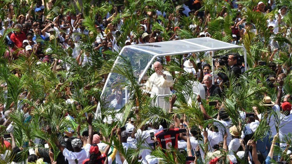 Pope Francis waves as he arrives prior to leading a mass in Mauritius