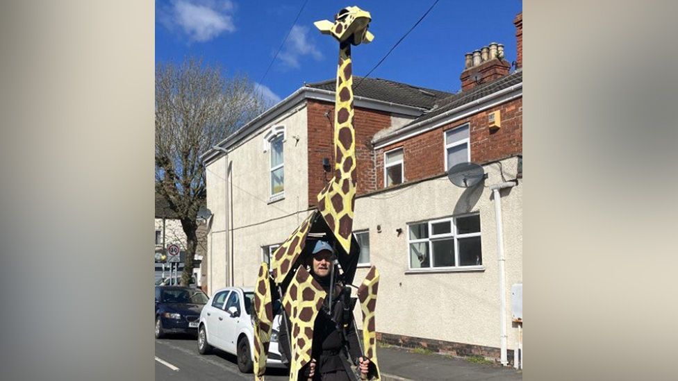 Puppeteer Sebastian Mayer poses inside his giraffe costume