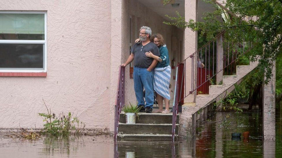Ken and Tina Kruse stand next to their apartment after the area flooded from Hurricane Idalia in Tarpon Springs, Florida