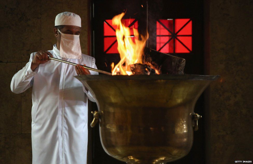 A cleric stokes the coals of the 'sacred eternal flame' at the Zoroastrian Fire Temple