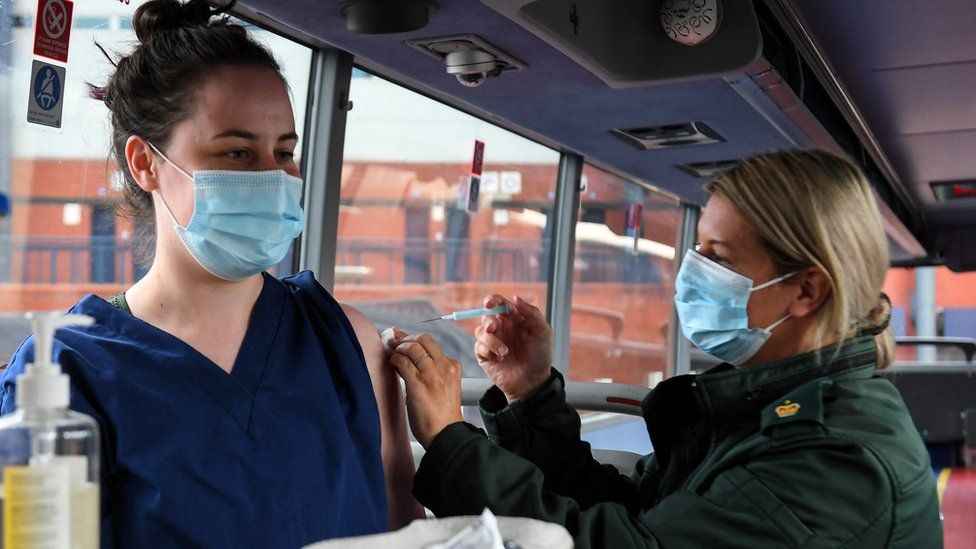 Cheryl Barr of the Scottish Ambulance Service, gives Fiona Douglas, 26, a vet from Falkirk, an injection of a Covid-19 vaccine on the Scottish Ambulance Service vaccine bus in Glasgow
