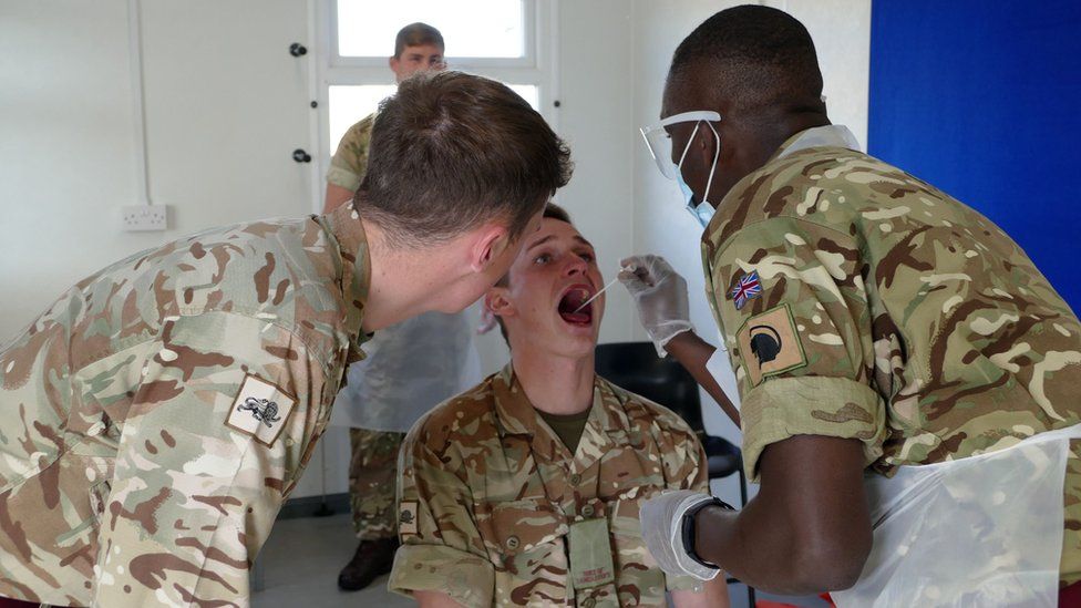 A handout picture taken on April 7, 2020 and released by the British Ministry of Defence (MOD) on April 9, 2020 shows members of 1st Battalion The Duke of Lancaster Regiment training other members of the regiment in how to test for coronavirus Covid-19 at Manchester Airport testing station in north-west England.