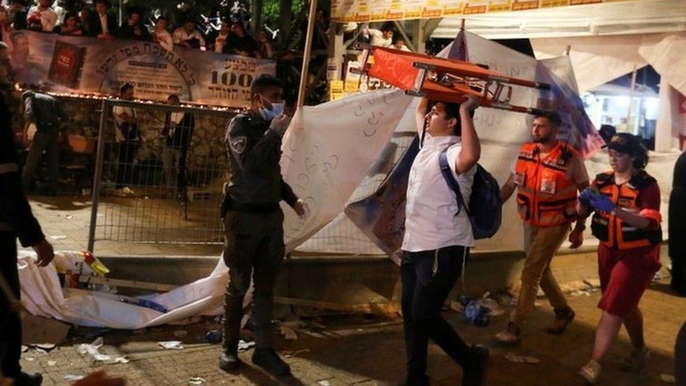 A man carries a stretcher after a crush at the Lag B'Omer festival