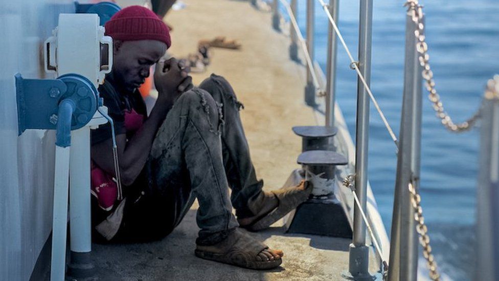 Un homme est assis, désemparé, sur le plancher du patrouilleur après avoir été intercepté par les autorités tunisiennes