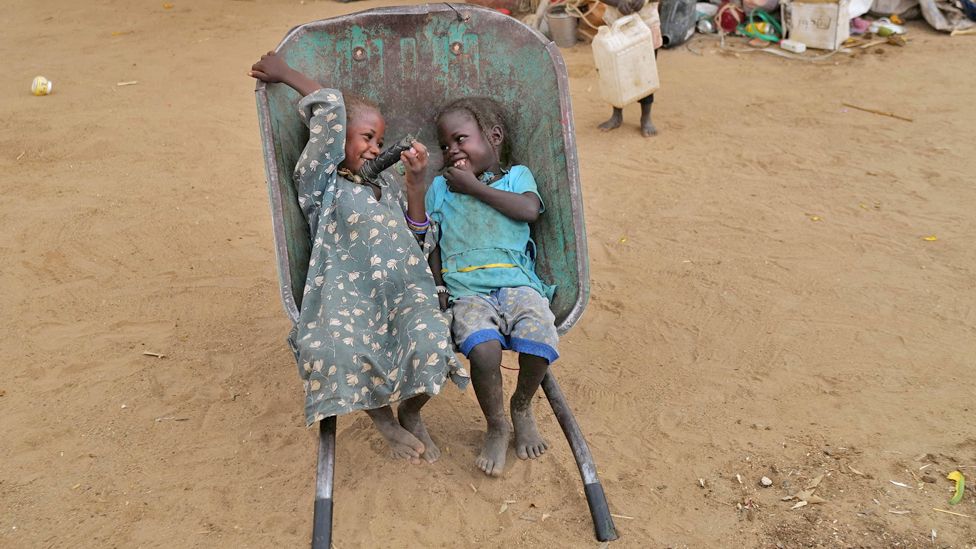 Two girls giggling in a wheelbarrow, Koufroun, Chad - Wednesday 10 May 2023