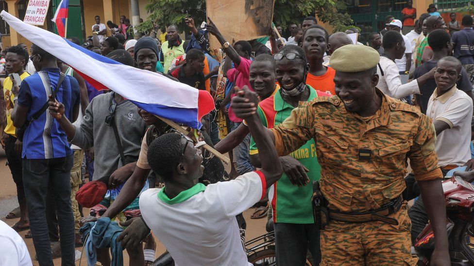 A man and a solider shaking hands during a rally in support of the coup in Ouagadougou, Burkina Faso