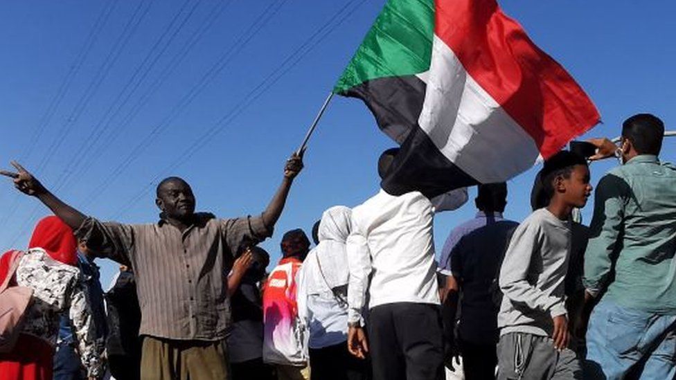 Man waves Sudanese flag in Khartoum (file photo)