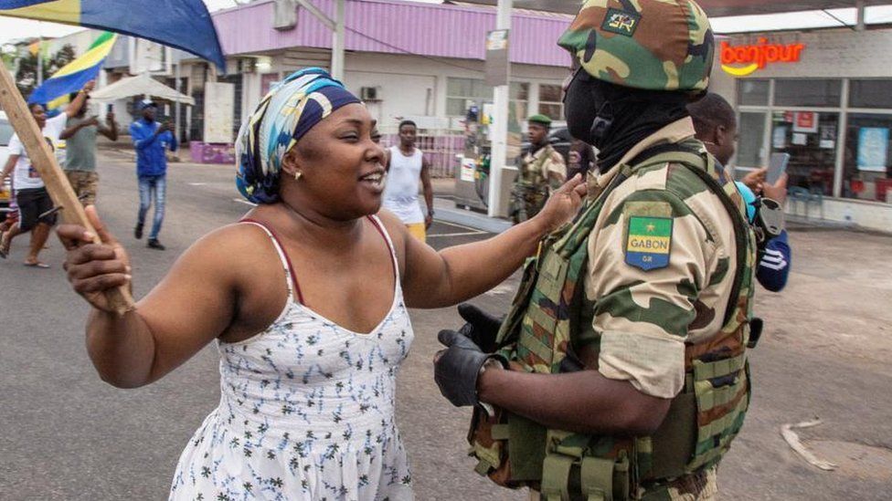 A woman interacts with a soldier as she celebrates with people in support of a putschists, in a street of Port-Gentil, Gabon August 30, 2023