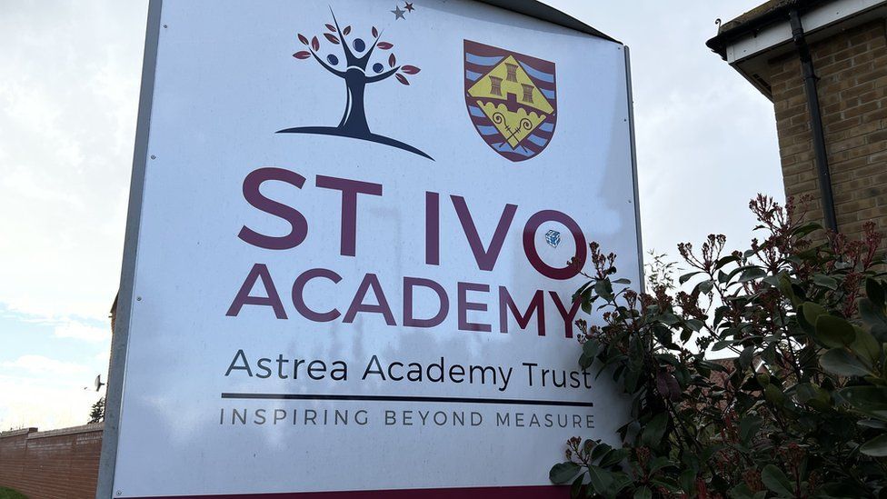 Large "St Ivo Academy" sign in red lettering on a white background