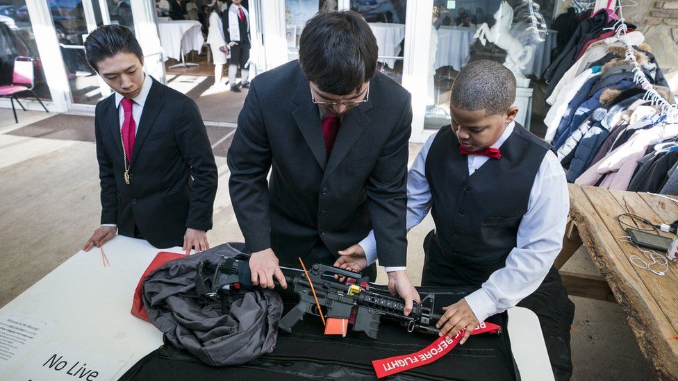 Miembros de la iglesia inspeccionan un AR-15