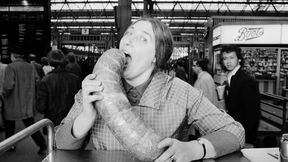 A woman poses with a large haggis in an old black and white photo